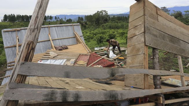 Warga membersihkan puing-puing rumah dan mengambil barang yang bisa dimanfaatkan dari rumahnya yang dirusak kawanan gajah liar di kawasan perkebunan kopi Desa Negeri Antara, Pintu Rime Gayo, Bener Meriah, Aceh, Kamis (2/12/2021). [ANTARA FOTO/Syifa Yulinnas]