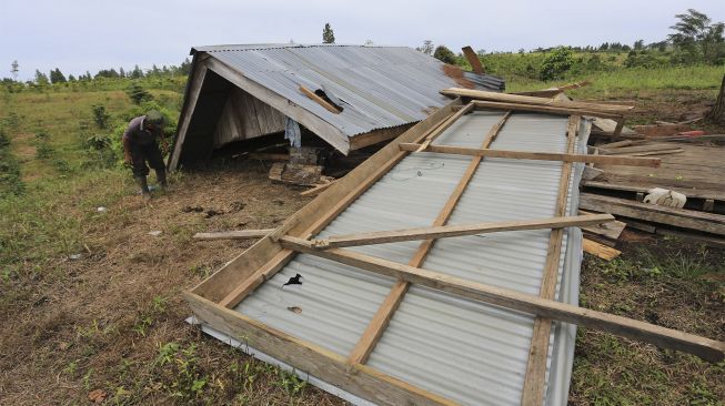 Warga membersihkan puing-puing rumah dan mengambil barang yang bisa dimanfaatkan dari rumahnya yang dirusak kawanan gajah liar di kawasan perkebunan kopi Desa Negeri Antara, Pintu Rime Gayo, Bener Meriah, Aceh, Kamis (2/12/2021). [ANTARA FOTO/Syifa Yulinnas]