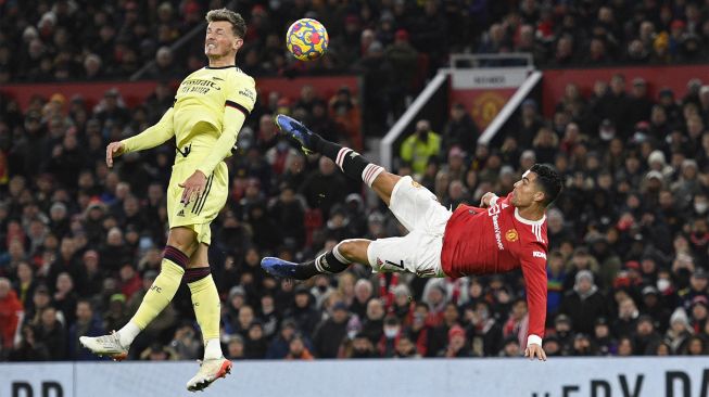 Striker Manchester United Cristiano Ronaldo (kanan) berusaha mencetak gol akrobatik selama pertandingan sepak bola Liga Premier Inggris antara Manchester United dan Arsenal di Old Trafford, Manchester, Inggris, pada (2/12/2021). [OLI SCARFF / AFP]