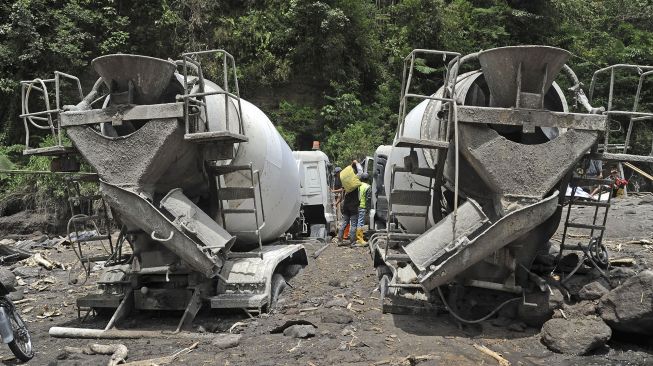 Pekerja mengamankan barang-barang dari dalam truk yang terjebak lahar hujan di aliran sungai Senowo kawasan lereng Gunung Merapi Dusun Trono, Krinjing, Dukun, Magelang, Jateng, Kamis (2/12/2021). [ANTARA FOTO/Anis Efizudin]