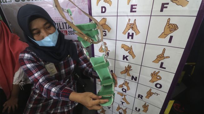 Petugas dinas sosial memperlihatkan alas kaki untuk warga berkebutuhan khusus pada pameran produk karya penyandang disabilitas memperingati Hari Disabilitas Internasional di Balai Kota Kediri, Jawa Timur, Jumat (3/12/2021). [ANTARA FOTO/Prasetia Fauzani]