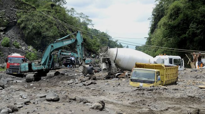 Pekerja menggunakan ekskavator mengevakuasi truk yang terjebak lahar hujan di aliran sungai Senowo kawasan lereng Gunung Merapi Dusun Trono, Krinjing, Dukun, Magelang, Jateng, Kamis (2/12/2021). [ANTARA FOTO/Anis Efizudin]