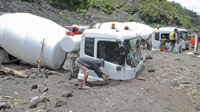 Pekerja menggali pasir di samping truk yang terjebak lahar hujan di aliran sungai Senowo kawasan lereng Gunung Merapi Dusun Trono, Krinjing, Dukun, Magelang, Jateng, Kamis (2/12/2021). [ANTARA FOTO/Anis Efizudin]