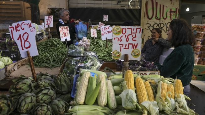 Orang-orang berbelanja di pasar di pusat kota pesisir Mediterania Israel Tel Aviv, Israel, pada (1/12/2021). [MENAHEM KAHANA / AFP]