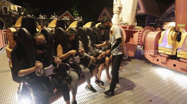 Pengunjung menaiki wahana permainan di Dunia Fantasi, Ancol, Jakarta, Jumat (3/12/2021). [Suara.com/Angga Budhiyanto]