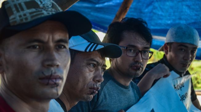 Imigran asal Afghanistan melakukan aksi jahit mulut saat berunjuk rasa di kantor Perwakilan International Organization for Migration (IOM) Pekanbaru, Riau, Sabtu (4/12/2021).  ANTARA FOTO/Yudhie