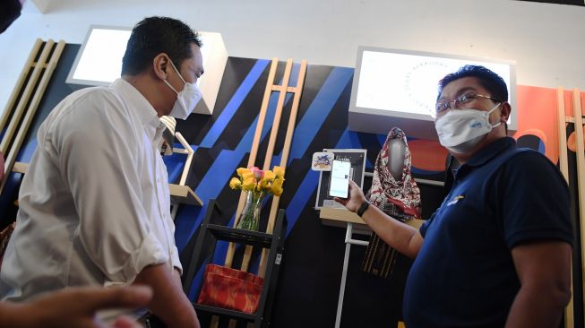 Direktur Utama Bank Mandiri Darmawan Junaidi (kanan) disaksikan Wakil Gubernur DKI Jakarta Ahmad Riza Patria membayar menggunakan pindai QR usai membuka Festival Diskon Nasional (FDN) 2021 di M Bloc Space, Jakarta, Sabtu (4/12/2021). ANTARA FOTO/Hafidz Mubarak A