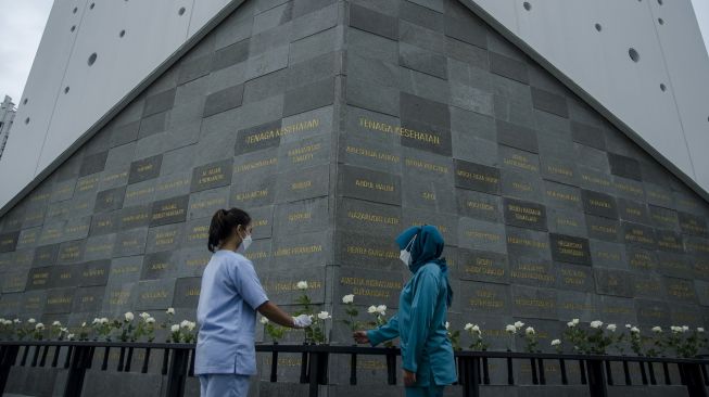 Warga meletakkan bunga di depan Monumen Pahlawan COVID-19 Jawa Barat, Bandung, Jawa Barat, Sabtu (4/12/2021).  ANTARA FOTO/Novrian Arbi