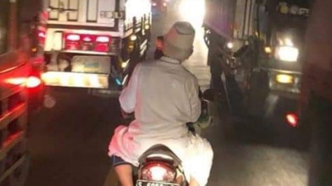 Gus Mus menaik motor membelah macetnya kepungan kendaraan umum. [Facebook]