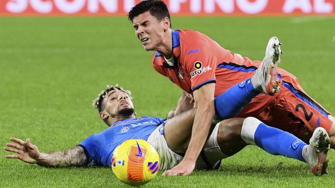 Bek Napoli Kevin Malcuit (kiri) menjegal gelandang Atalanta Matteo Pessina selama pertandingan sepak bola Serie A Italia antara Napoli dan Atalanta di stadion Diego-Maradona, Naples, pada (4/12/2021). [FILIPPO MONTEFORTE / AFP]