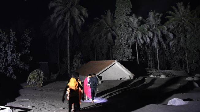 Warga mengamati kondisi rumah yang tertimbun abu vulkanik dari guguran awan panas Gunung Semeru di Desa Sumber Wuluh, Lumajang, Jawa Timur, Minggu (5/12/2021). [ANTARA FOTO/Zabur Karuru]