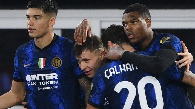 Bek Inter Milan Denzel Dumfries (kanan) merayakan dengan pemain depan Inter Milan Joaquin Correa, gelandang Inter Milan Nicolo Barella dan gelandang Inter Milan Hakan Calhanoglu setelah mencetak gol ketiga timnya selama pertandingan sepak bola Serie A Italia antara AS Roma dan Inter di stadion Olimpiade, Roma, pada (4/12/2021). [VINCENZO PINTO / AFP]