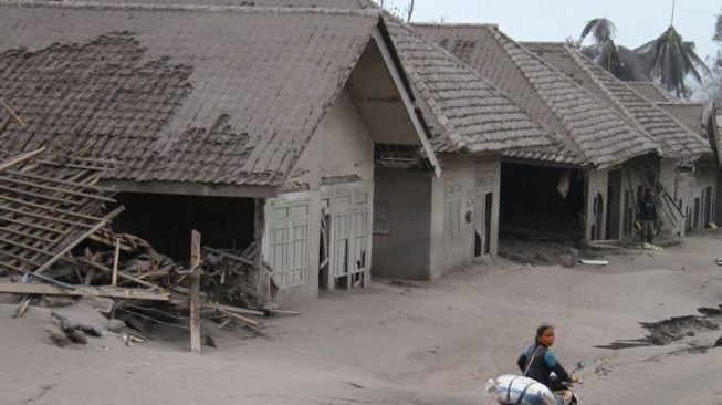 Seorang warga mengangkut barang yang bisa diselamatkan dari rumahnya yang hancur akibat erupsi gunung Semeru di desa Supiturang, Lumajang, Jawa Timur, Minggu (5/12/2021). Luncuran awan panas akibat letusan gunung Semeru mengakibatkan puluhan rumah di dua kecamatan rusak dan delapan kecamatan terdampak abu vulkanik. ANTARA FOTO/Ari Bowo Sucipto/foc.