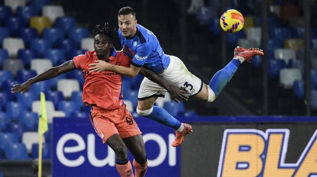 Pemain depan Atalanta Duvan Zapata (kiri) dan pemain belakang Napoli Amir Rrahmani mengejar bola selama pertandingan sepak bola Serie A Italia antara Napoli dan Atalanta di stadion Diego-Maradona, Naples, pada (4/12/2021). [FILIPPO MONTEFORTE / AFP]