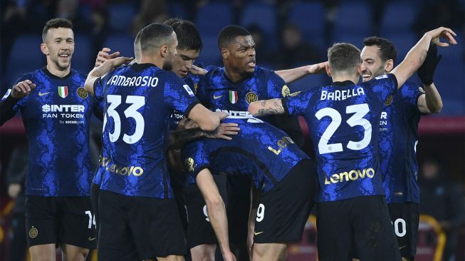 Pemain depan Inter Milan Edin Dzeko (tengah) merayakan dengan rekan satu timnya setelah mencetak gol kedua selama pertandingan sepak bola Serie A Italia antara AS Roma dan Inter di stadion Olimpiade, Roma, pada (4/12/2021). [VINCENZO PINTO / AFP]