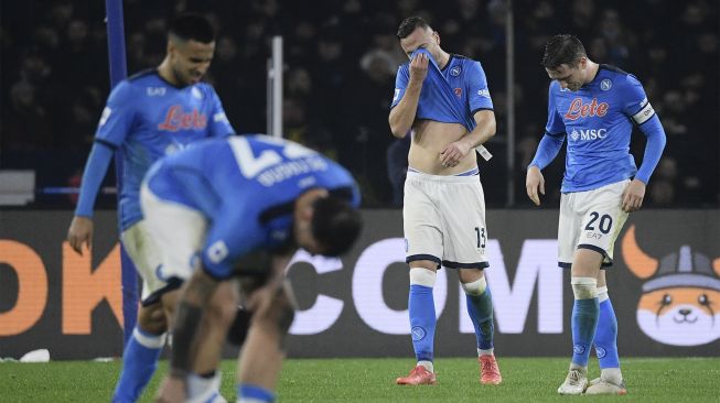 Bek Napoli Amir Rrahmani (tengah) dan gelandang Napoli Piotr Zielinski (kanan) bereaksi pada akhir pertandingan sepak bola Serie A Italia antara Napoli dan Atalanta di stadion Diego-Maradona, Naples, pada (4/12/2021). [FILIPPO MONTEFORTE / AFP]