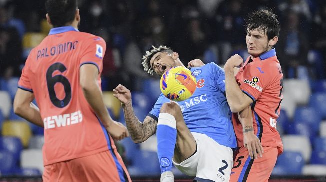 Bek Napoli Kevin Malcuit (tengah) dan gelandang Atalanta Marten de Roon (kanan) bertabrakan selama pertandingan sepak bola Serie A Italia antara Napoli dan Atalanta di stadion Diego-Maradona, Naples, pada (4/12/2021). [FILIPPO MONTEFORTE / AFP]