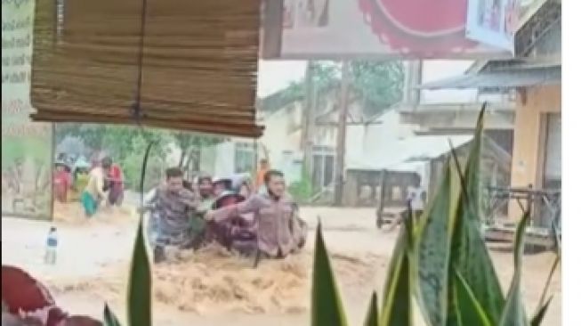 viral polisi jadi tameng emak-emang terjang arus banjir yang deras di kawasan Sumenep. [ini_polisi / Instagram]