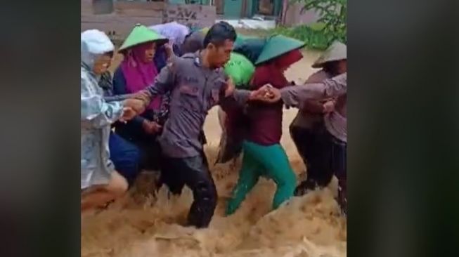 Viral! Dua Polisi Terjang Banjir Demi Evakuasi Ibu-ibu di Kangean Madura