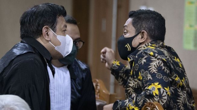 Terdakwa mantan penyidik KPK AKP Stepanus Robin Pattuju (kanan) berdiskusi dengan penasihat hukumnya sebelum sidang pembacaan tuntutan di Pengadilan Tipikor, Jakarta, Senin (6/12/2021). ANTARA FOTO/Aditya Pradana Putra