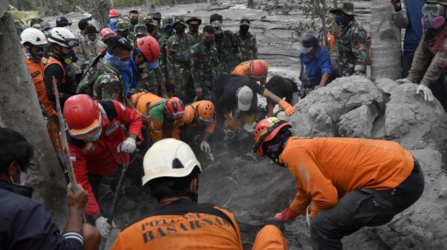 Tim SAR gabungan mengevakuasi jenazah korban yang tertimbun material guguran awan panas Gunung Semeru saat operasi pencarian korban di Desa Sumberwuluh, Lumajang, Jawa Timur, Senin (6/12/2021).  ANTARA FOTO/Zabur Karuru