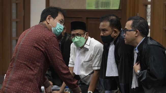 Terdakwa Azis Syamsuddin (kiri) berdiskusi dengan tim kuasa hukumnya usai menjalani sidang perdana kasus suap mantan penyidik KPK AKP Stepanus Robin Pattuju alias Robin di Pengadilan Tipikor, Jakarta, Senin (6/12/2021). ANTARA FOTO/Aditya Pradana Putra