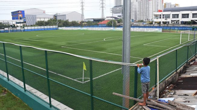 Seorang anak melihat Lapangan Sepakbola Muara Angke yang telah dibangun di Jakarta Utara, Minggu (5/12/2021).  ANTARA FOTO/Indrianto Eko Suwarso