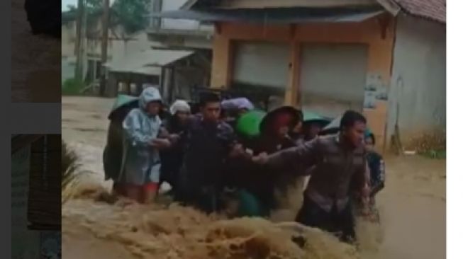 Viral Petugas Polisi Jadi Tameng Emak-emak Terjang Arus Banjir, Netizen Ikut Semangati