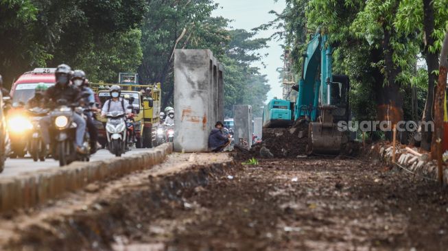 Suasana pembangunan saluran air di Jalan I Gusti Ngurah Rai, Duren Sawit, Jakarta Timur, Selasa (7/12/2021). [Suara.com/Alfian Winanto]