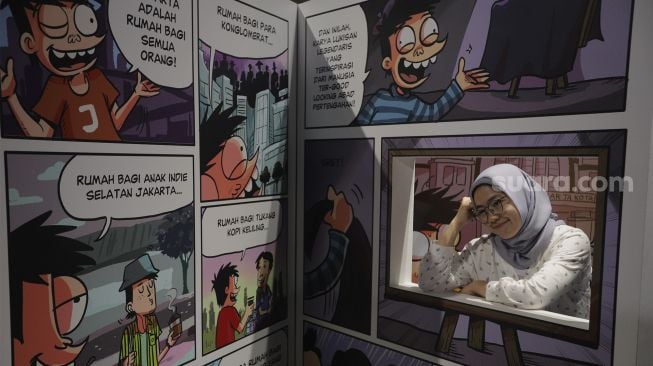 Pengunjung berfoto di instalasi seni dalam pameran Popart Jakarta di Space8 Astha, Kawasan Niaga Terpadu Sudirman, Kebayoran Baru, Jakarta, Selasa (7/12/2021). [Suara.com/Angga Budhiyanto]