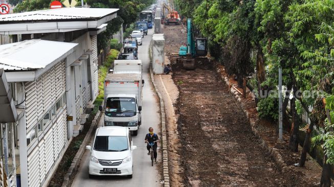 Suasana pembangunan saluran air di Jalan I Gusti Ngurah Rai, Duren Sawit, Jakarta Timur, Selasa (7/12/2021). [Suara.com/Alfian Winanto]