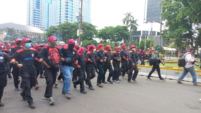 Massa buruh saat menggelar long march terkait demo kenaikan UMP di Jakarta. (Suara.com/Yaumal)