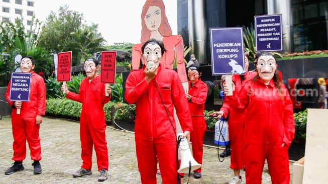 Sejumlah aktivis dari Indonesia Corruption Watch (ICW) dan Gerakan #BersihkanIndonesia mengenakan kostum dari film Money Heist saat melakukan aksi unjuk rasa di Gedung KPK, Jakarta Selatan, Rabu (8/12/2021). [Suara.com/Alfian Winanto]