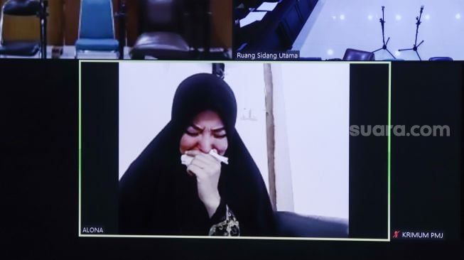 Artis Cynthiara Alona menangis ketika mendengar putusan majelis hakim saat menjalani sidang kasus prostitusi anak yang digelar secara virtual di Pengadilan Negeri Tangerang, Banten, Rabu (8/12/2021). [Suara.com/Alfian Winanto]