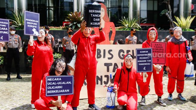 Sejumlah aktivis dari Indonesia Corruption Watch (ICW) dan Gerakan #BersihkanIndonesia mengenakan kostum dari film Money Heist saat melakukan aksi unjuk rasa di Gedung KPK, Jakarta Selatan, Rabu (8/12/2021). [Suara.com/Alfian Winanto]