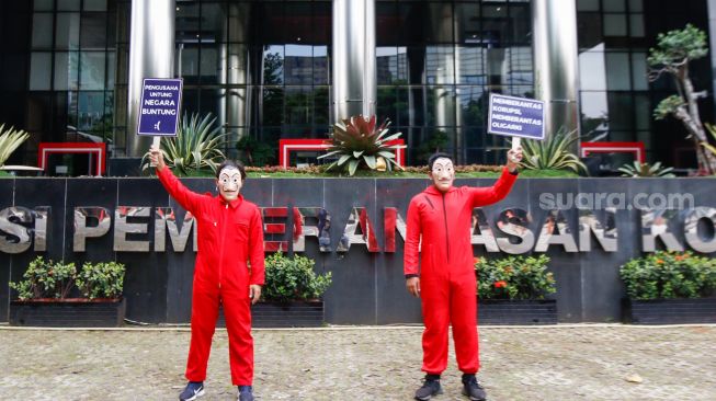 Sejumlah aktivis dari Indonesia Corruption Watch (ICW) dan Gerakan #BersihkanIndonesia mengenakan kostum dari film Money Heist saat melakukan aksi unjuk rasa di Gedung KPK, Jakarta Selatan, Rabu (8/12/2021). [Suara.com/Alfian Winanto]