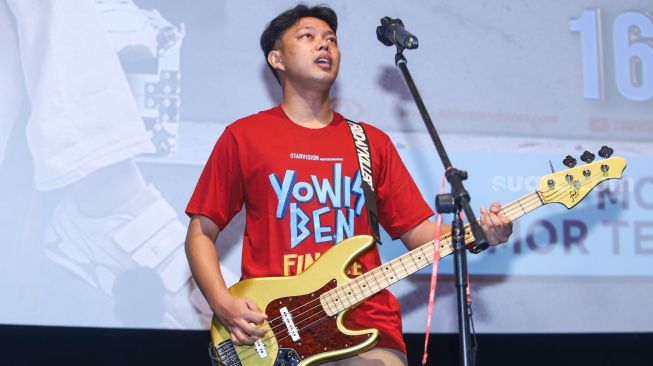 Aksi Bayu Eko Moektito atau Bayu Skak bermain musik saat gala premiere film 'Yowis Ben Finale' di Kuningan, Jakarta Selatan, Kamis (9/12/2021). [Suara.com/Alfian Winanto]