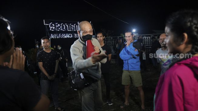 Para peserta mendengarkan arahan sebelum memulai kompetisi Water Adventure Jelajah Air Nusantara di Desa Ciasihan, Kecamatan Pamijahan, Kabupaten Bogor, Jawa Barat, Rabu (8/12/2021) malam. [Suara.com/Angga Budhiyanto]