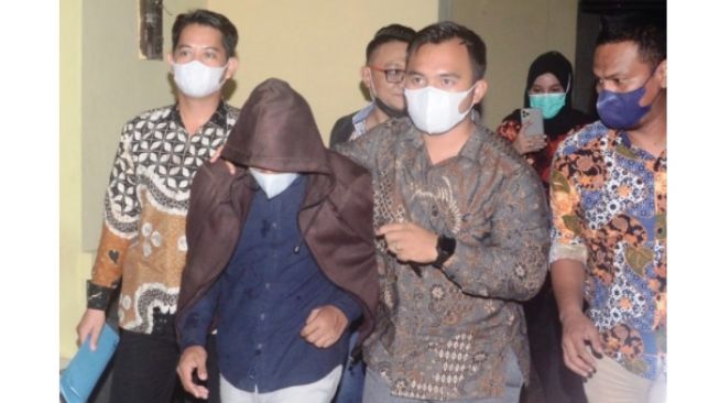 Dosen Reza Ghasarma (tengah) saat akan ditahan di Mapolda Sumsel [Welly/JT]