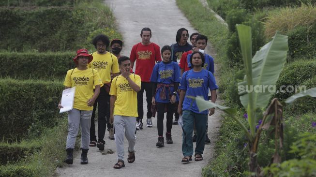 Para peserta berjalan menuju lokasi kompetisi Water Adventure Jelajah Air Nusantara di Desa Ciasihan, Kecamatan Pamijahan, Kabupaten Bogor, Jawa Barat, Kamis (9/12/2021). [Suara.com/Angga Budhiyanto]