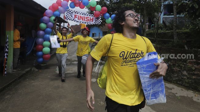 Tim dari Gilang Bhaskara berlari melewati garis finish saat mengikuti kompetisi Water Adventure Jelajah Air Nusantara di Desa Ciasihan, Kecamatan Pamijahan, Kabupaten Bogor, Jawa Barat, Kamis (9/12/2021). [Suara.com/Angga Budhiyanto]