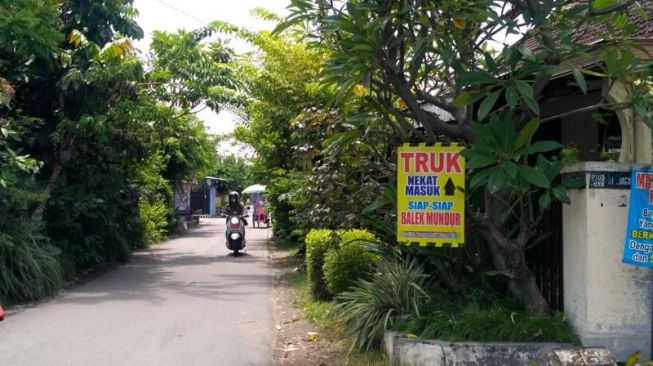 Poster yang dipasang di sepanjang Jl Kali Kampar, Kampung Jagalan, Jebres, Kota Solo, untuk mengingatkan pengendara. Foto diambil Jumat (10/12/2021). (Solopos.com/Chelin Indra Sushmita)