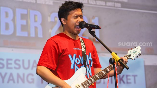 Aksi Joshua Suherman bermain musik saat gala premiere film 'Yowis Ben Finale' di Kuningan, Jakarta Selatan, Kamis (9/12/2021). [Suara.com/Alfian Winanto]