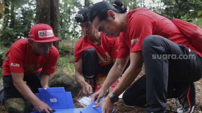 Tim dari Rikas Harsa berusaha menyelesaikan tantangan dalam kompetisi Water Adventure Jelajah Air Nusantara di Desa Ciasihan, Kecamatan Pamijahan, Kabupaten Bogor, Jawa Barat, Kamis (9/12/2021). [Suara.com/Angga Budhiyanto]