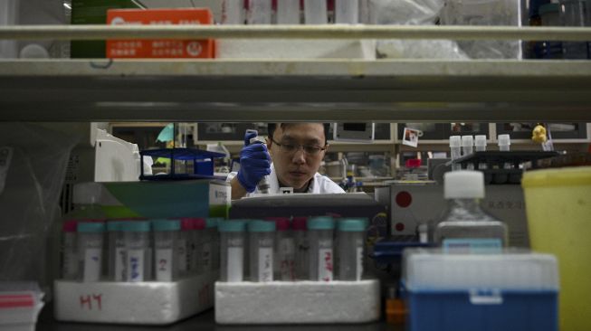 Seorang teknisi laboratorium bekerja di laboratorium Universitas Tsinghua, Beijing, China, pada (9/12/2021). [NOEL CELIS / AFP]