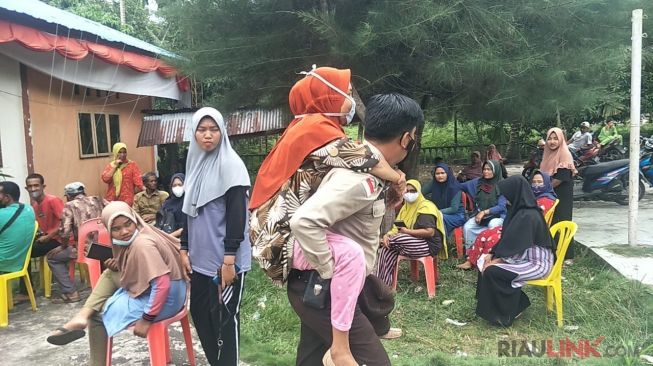 Polisi Gendong Ibu-ibu ke Posko Vaksin di Desa Anak Setatah