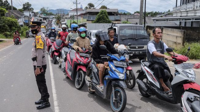 Polisi mengawasi lalu lintas saat terjadi antrean pengendara untuk mengisi bahan bakar minyak (BBM) di SPBU Kampak, Kota Pangkalpinang, Kepulauan Bangka Belitung, Sabtu (11/12/2021). [ANTARA FOTO/Resha Juhari]