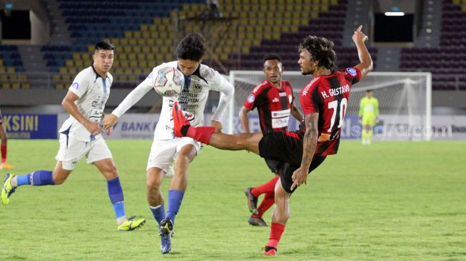 Gelandang PSIS Semarang, Damas Damar Jati berebut bola dengan gelandang Persipura Jayapura, Gustavo Hedipo dalam laga pekan ke-16 BRI Liga 1  di Stadion Manahan, Solo, Sabtu (11/12/2021). [Suara.com/Ronald Seger Praboowo]