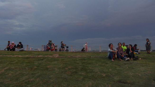 Warga menyaksikan matahari tenggelam saat mengunjungi kawasan Pantai Maju, Pantai Indah Kapuk (PIK), Kamal Muara, Jakarta, Sabtu (11/12/2021). ANTARA FOTO/Wahyu Putro 