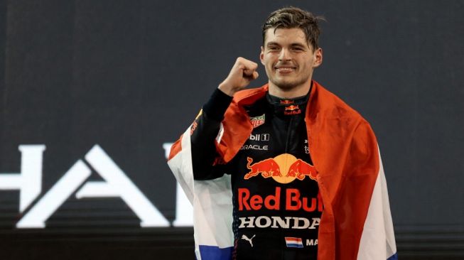 Sang juara dunia F1 2021 dari tim Red Bull, Max Verstappen melakukan selebrasi di podium Sirkuit Yas Marina, Abu Dhabi, Uni Emirat Arab, Minggu (12/12/2021) malam WIB. [KAMRAN JEBREILI / POOL / AFP]
